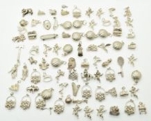 A collection of silver and white metal charms including shells, purses, rocking horses and churches,