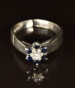 An 18ct white gold ring set with a diamond and sapphires (band cut), 3.4g