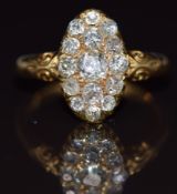 A late Victorian 18ct gold ring set with old cut diamonds in an oval setting, the centre diamond
