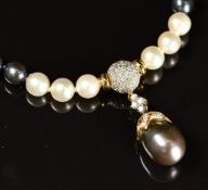 A single strand of cream and black South Sea pearls with 14k gold pendant section set with