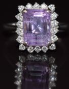 An 18ct white gold ring set with an emerald cut amethyst surrounded by diamonds, 3.9g, size M