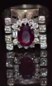 An 18ct gold ring set with a 1.3ct oval cut ruby surrounded by round and baguette cut diamonds, 11.
