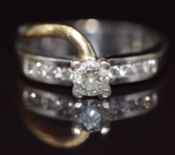 An 18ct gold bi-coloured ring set with a round cut diamond of approximately 0.4ct, and further