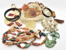 A large agate necklace, three jade style carved pendants, a large white metal pendant set with