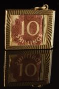 A 9ct gold pendant / charm set with a 10 shilling note