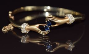 A 14k gold bangle in the form of two hands, set with marquise cut sapphires and diamonds, 15.3g