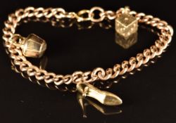 A 9ct gold charm bracelet with three 9ct gold charms including a shoe, dice and kettle, 23.2g