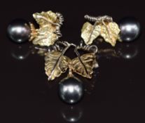 A suite of 18ct gold jewellery set with Tahitian pearls comprising earrings and pendant / brooch