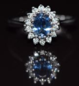 A 9ct white gold ring set with a sapphire of approximately 0.8ct surrounded by diamonds, 3.3g,