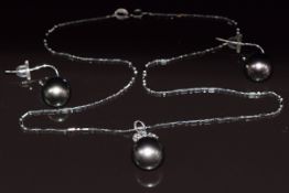 An 18ct white gold pendant set with a 13ct black South Sea pearl, three marquise cut diamonds and