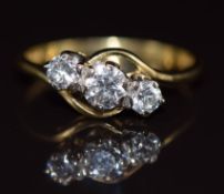 An 18ct gold ring set with three diamonds in a twist setting, the centre diamond approximately 0.