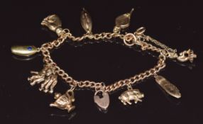 A 9ct gold charm bracelet with 9ct gold charms including monkeys, cat, kidney bean set with a