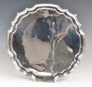 Elizabeth II hallmarked silver salver with shaped edge, raised on four scroll feet, London 1977 J