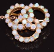 A 9ct rose gold brooch made up of three interlocking circles set with opal cabochons, 6.8g
