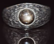 An 18k white gold ring set with a star sapphire, 7.8g, size X