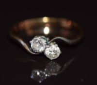 An 18ct gold ring set with two diamonds in a twist setting, 1.8g, size L