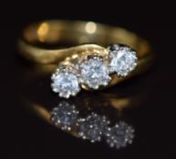An 18ct gold ring set with three diamonds in a twist setting, total diamond weight approximately 0.