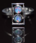 An 18k white gold ring set with two black opal triplets, 5.4g, size J