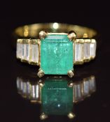 An 18k gold ring set with an emerald cut emerald of approximately 1.9ct and six baguette cut