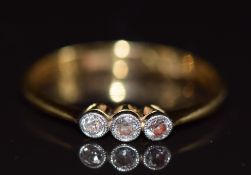 An 18ct gold ring set with three diamonds (cut band), 2g
