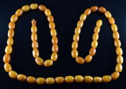 A 1920's Baltic amber necklace made up of sixty butterscotch / egg yolk coloured oval beads, the