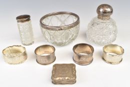 Four hallmarked silver napkin rings, three hallmarked silver mounted cut glass items, one Asrey, and