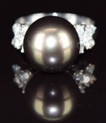 An 18ct white gold ring set with a 14ct black South Sea pearl and five diamonds to each shoulder,