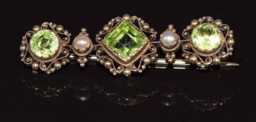 A yellow metal brooch set with three peridots and pearls, 3.8g, in antique box