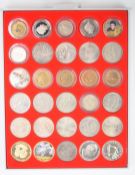 A collection of modern crowns and commemorative coins, contained in a Lindner display case
