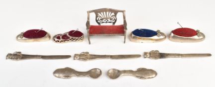 Five novelty white metal pin cushions, four formed as shoes marked 925 and one formed as a sofa,