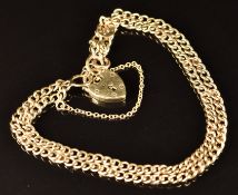 A 9ct gold double curb link bracelet mounted with horseshoe decoration, with heart padlock clasp,
