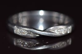 A platinum wedding band / ring with twisted design to fit an engagement ring, set with six round