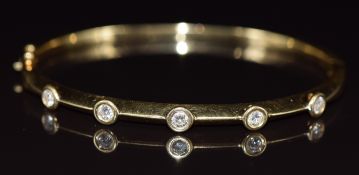 An 18ct gold bangle set with five diamonds, each approximately 0.12ct, 21.1g