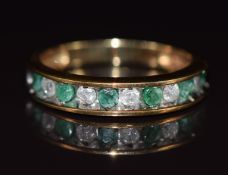 A 10k gold half eternity ring set with alternating emeralds and diamonds, 2.5g, size L