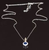 A 14k gold bi-coloured reversible pendant set with an oval cut emerald, oval cut sapphire and