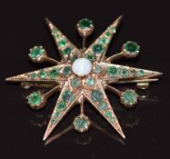 A 9k gold brooch in the form of a star set with an opal and emeralds, 7.9g