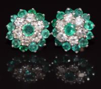 A pair of platinum earrings set with emeralds and diamonds in a cluster, 5.8g