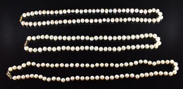 Three single strands of cultured pearls with 9ct gold clasps, together with a Mikimoto box