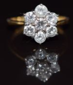 An 18ct gold ring set with seven diamonds in a cluster, total diamond weight approximately 1ct, 2.