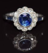 Art Deco platinum ring set with a round cut sapphire surrounded by diamonds, with further baguette