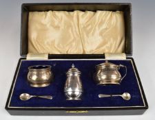 Cased George VI hallmarked silver three piece cruet set with blue glass liners, Birmingham 1937,