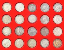 A collection of crowns etc comprising Queen Victoria, George IV and George V, contained in a Lindner