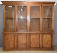 Victorian mahogany four door bookcase with sawtooth adjustable shelves behind four glazed doors, the
