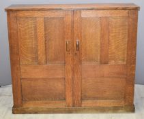 Arthur W Simpson Arts & Crafts oak cupboard with panelled doors opening to reveal variously sized