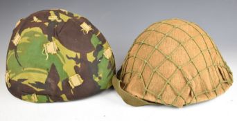 Two British combat helmets comprising a Brodie style Cold War era example with hessian cover and net