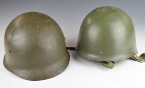 Two steel combat helmets, one French marked Dunois Cousance 1986 the other American, both with
