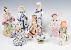 Collection of bisque nodding head figures including a Chinese figure with moving tongue, tallest