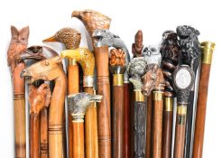 Approximately twenty walking sticks / canes in an oak umbrella or stick stand, the sticks include