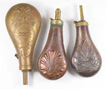 Three copper and brass powder flasks, two with embossed US coat of arms or similar, largest 23cm
