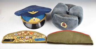 Four Russian hats with small collection of pin badges